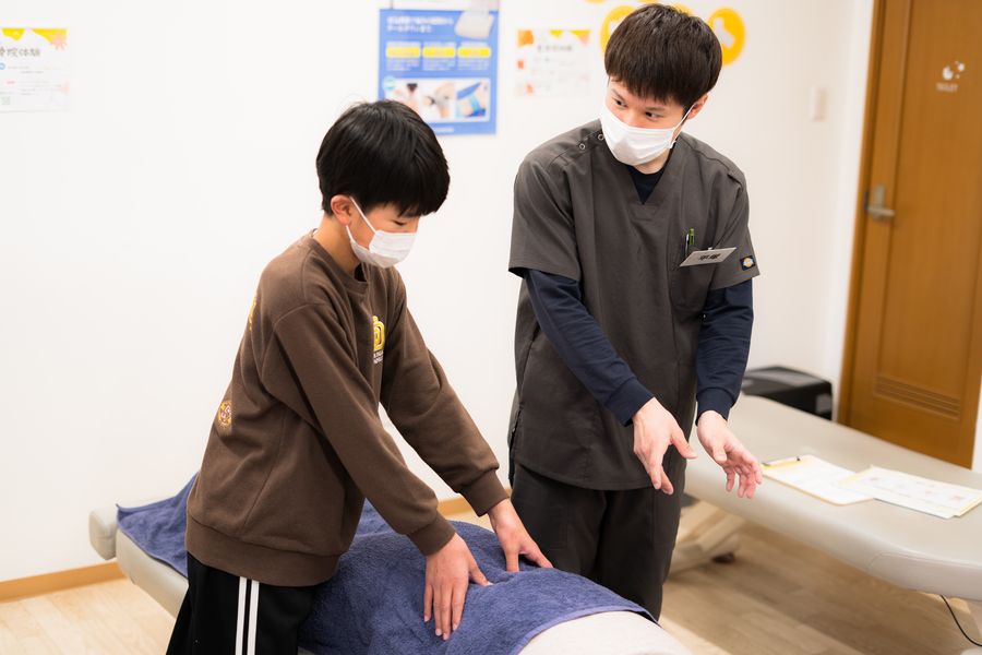 施術のやり方を教わる子ども