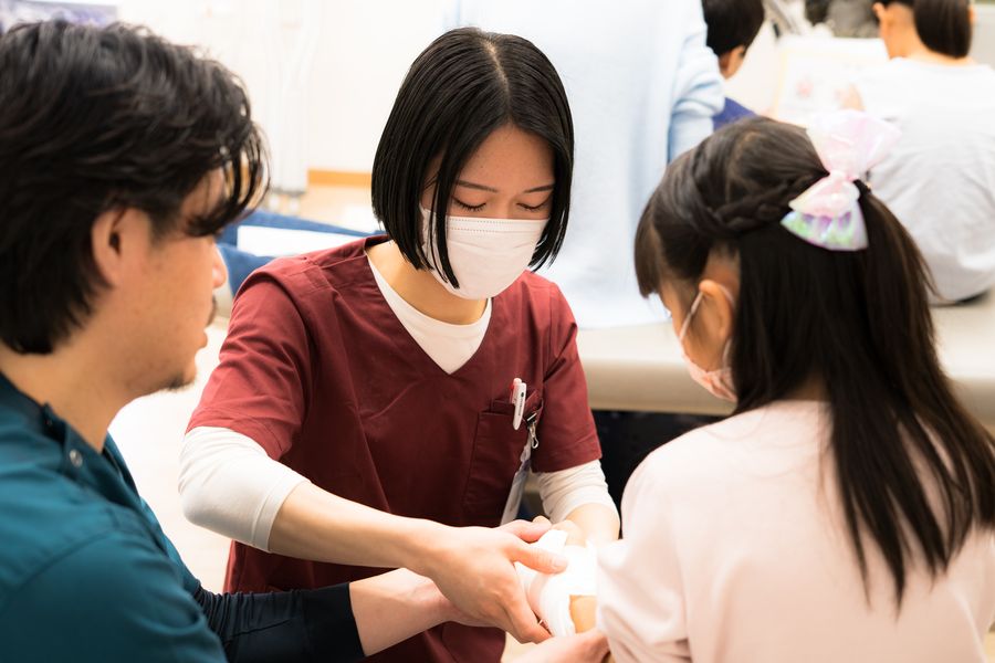 包帯の巻き方を体験する子ども